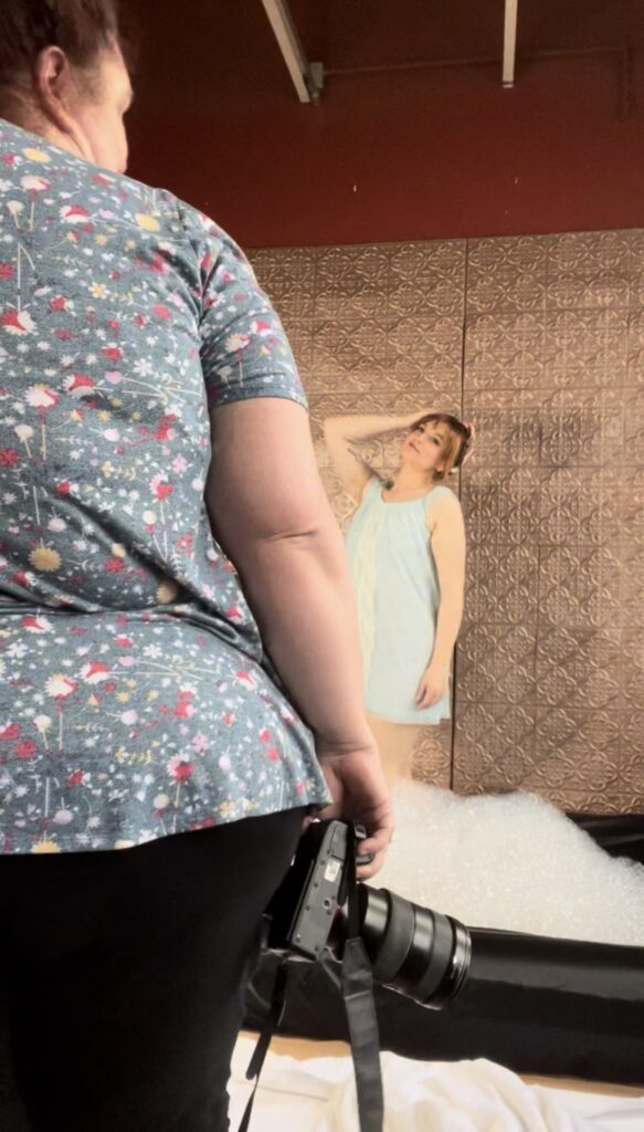 Woman standing in bubbles in a photo studio in Minneapolis and is being guided by her photographer. 