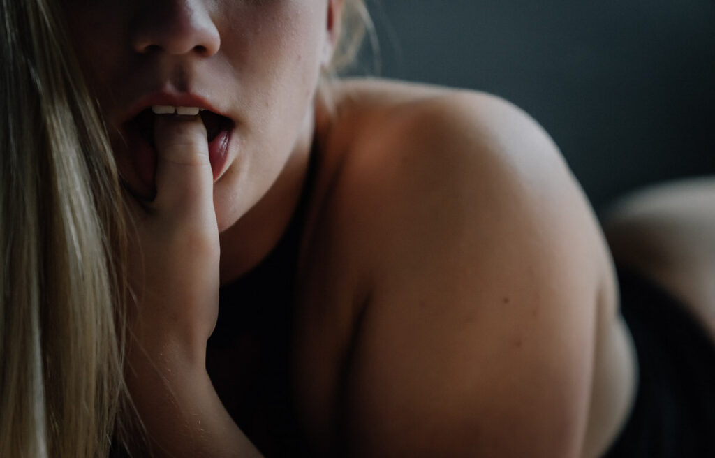 woman with blonde hair  biting her thumb 
