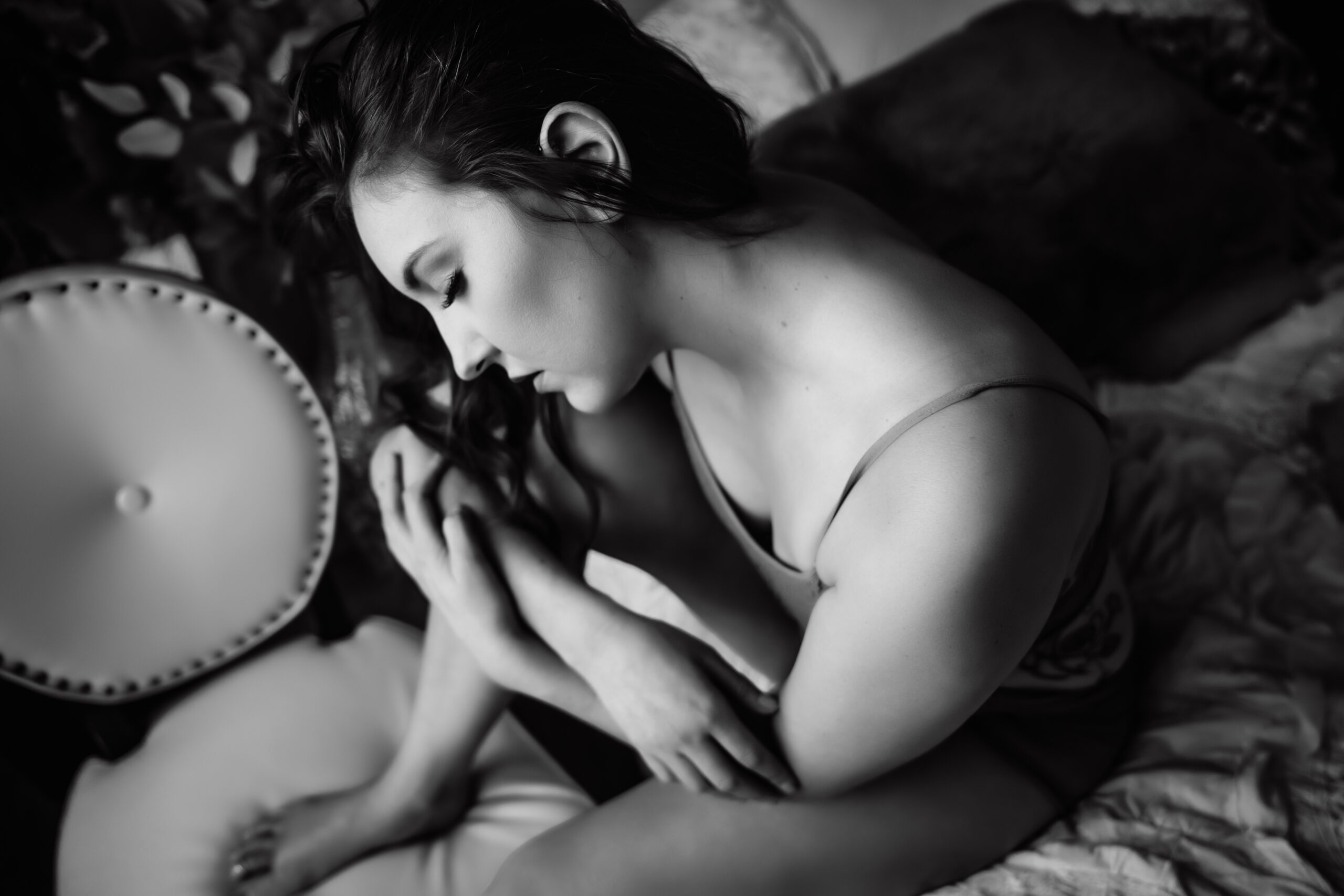 Black and white image of a woman hugging her knee